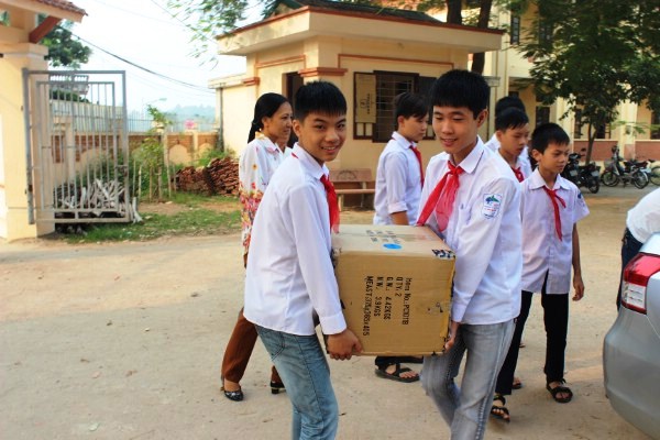 Học sinh Trường THCS Đường Lâm vui mừng khi vận chuyển sách, truyện từ đoàn từ thiện của báo.
