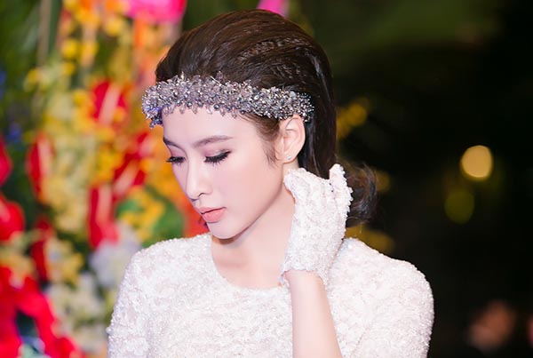 Cô mặc chiếc váy trắng đơn giản của nhà thiết kế Lê Thanh Hoà kết hợp với những phụ kiện đầy bắt mắt.