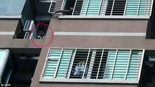 Lực lượng đưa dây cho người đàn ông đang trốn ngoài cửa sổ căn hộ chung cư.