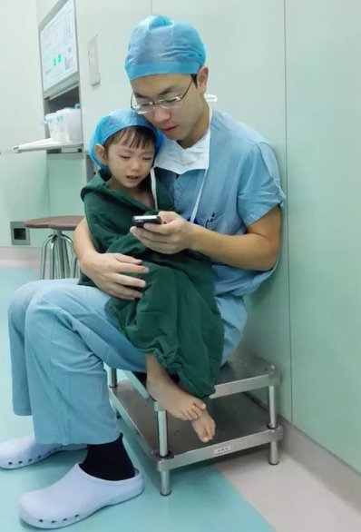 Bức ảnh bác sĩ ôm bé gái vỗ về trước ca phẫu thuật đốn tim dân mạng Trung Quốc.