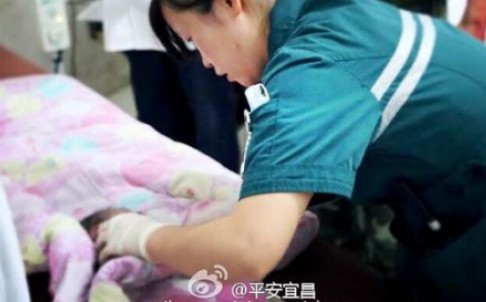 
Một y tá chăm sóc cho bé sơ sinh sau khi e được giải cứu khỏi ống thoát nước nhà vệ sinh. Ảnh Baidu
