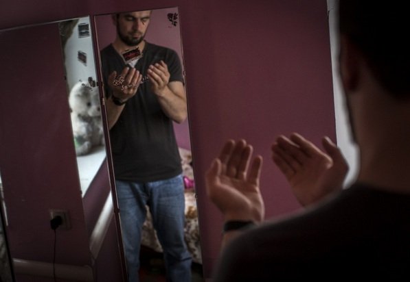 
Ahmed, một thanh niên làng Novosasitli từng tới Syria tham chiến trong vài tháng đang cầu nguyện trước gương tại nhà. Ảnh Dmitri Beliakov/Washington Post

