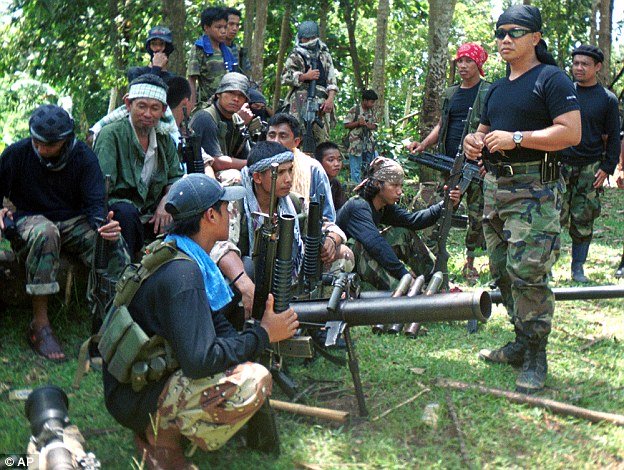 
Các chiến binh khủng bố Abu Sayyaf ngồi nghỉ trong một khu rừng ở Philippines. Ảnh: Daily Mail
