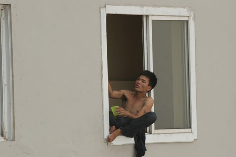 
Vũ Văn Tuyền trên cửa sổ tầng 21.
