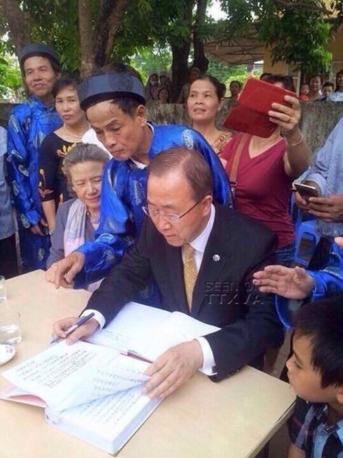 Ngài Ban Ki-moon (Phan Cơ Văn) đang ghi lưu bút trong chuyến thăm,đứng sau là cụ Phan Huy Giám