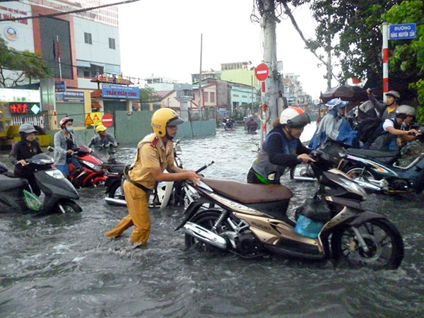 
CSGT giúp người dân đẩy xe giữa đường phố ngập vì mưa lớn.
