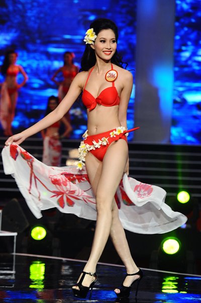 Hoa hậu Việt Nam 2012 Đặng Thu Thảo vừa cài hoa lên mái tóc vừa khéo léo quấn vòng hoa quanh hông để tạo điểm nhấn cho phần thi bikini của mình.