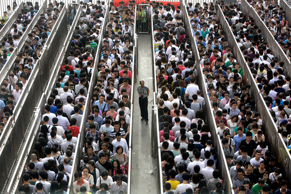 
Cảnh xếp hàng rồng rắn xuất hiện khi Bắc Kinh quyết định áp dụng biện pháp an ninh chống khủng bố tại các ga lớn. Một nhân viên an ninh đứng gác trong khi các hành khách xếp hàng và chờ tới lượt kiểm tra trong giờ cao điểm buổi sáng tại ga Bắc Tiantongyuan.
