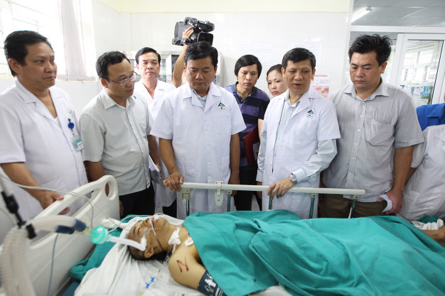 Bộ trưởng Đinh La Thăng và các lãnh đạo Bộ y tế và lãnh đạo tỉnh Lào Cai thăm hỏi những người bị nạn đang được cấp cứu tại Bệnh viện Đa khoa tỉnh Lào Cai - Ảnh: Nguyễn Khánh