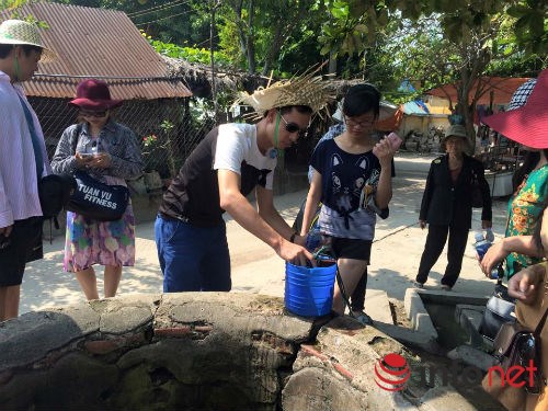 
Du khách uống nước giếng ở Cù Lao Chàm.

