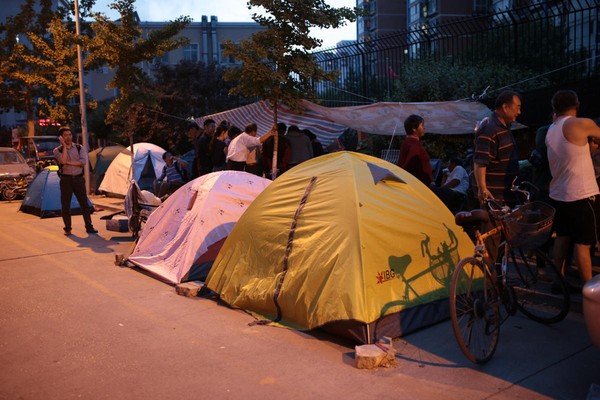 Hình ảnh những người dân dựng lều, căng lán ở trước cổng trường.