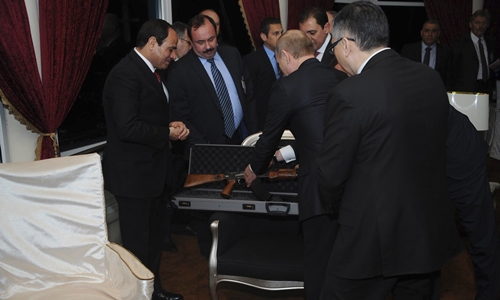 Egyptian President Abdel Fattah al-Sisi (L) looks on as he and Russian President Vladimir Putin (C) exchange presents during Putins visit in Cairo, February 9, 2015, in this handout courtesy of The Egyptian Presidency. Picture taken February 9. REUTERS/The Egyptian Presidency/Handout via Reuters (EGYPT - Tags: POLITICS SOCIETY) ATTENTION EDITORS - THIS PICTURE WAS PROVIDED BY A THIRD PARTY. REUTERS IS UNABLE TO INDEPENDENTLY VERIFY THE AUTHENTICITY, CONTENT, LOCATION OR DATE OF THIS IMAGE. NO SALES. NO ARCHIVES. FOR EDITORIAL USE ONLY. NOT FOR SALE FOR MARKETING OR ADVERTISING CAMPAIGNS. THIS PICTURE IS DISTRIBUTED EXACTLY AS RECEIVED BY REUTERS, AS A SERVICE TO CLIENTS