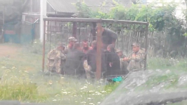 Binh lính Ukraine say rượu bị phạt nhốt trong chiếc cũi sắt.