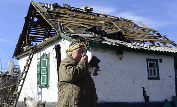 Một cụ bà đau buồn đứng trước ngôi nhà bị phá hủy ở Nikishyne,  đông nam Debaltseve, Ukraine.