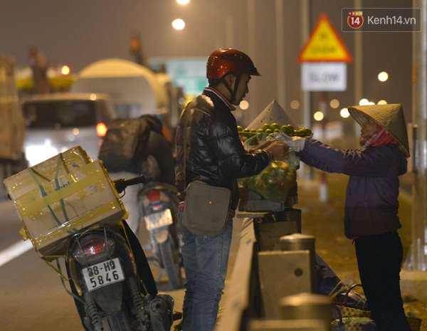 Nhiều người tranh thủ lúc chờ đường thông thoáng dừng mua hoa quả ngay ven đường.