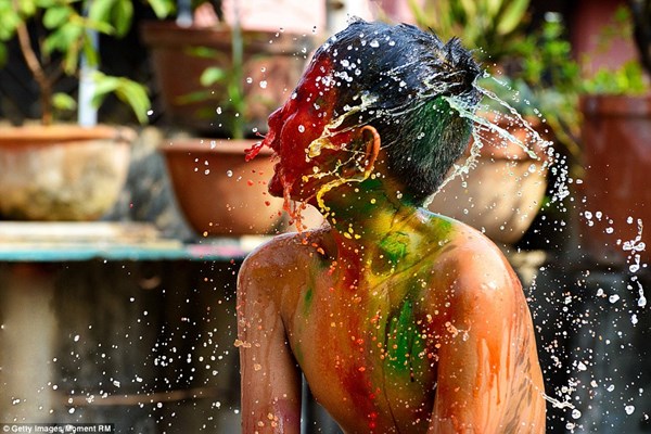 Một cậu bé đang rửa sạch những bột màu bám trên người sau khi tham gia lễ hội Holi. Người Ấn Độ thường dùng dầu để giúp dễ dàng tẩy rửa bột màu hơn