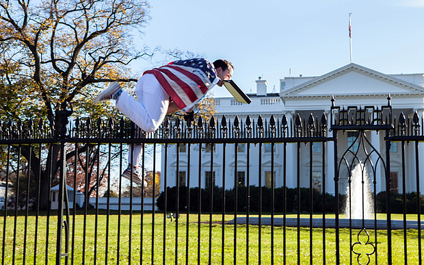 
Người đàn ông quấn quốc kỳ Mỹ và trèo rào vào Nhà Trắng.
