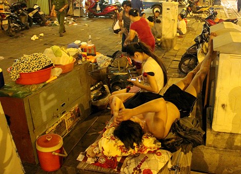 Đôi bạn trẻ ngủ tạm trên một chiếc bàn mượn của hàng xóm trên vỉa hè đường Võ Văn Kiệt 