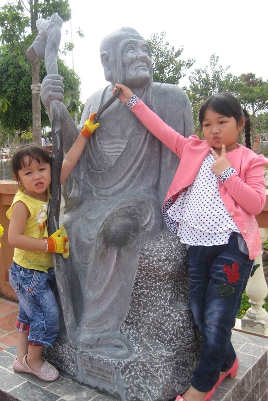 Trẻ em thích thú với những bức tượng đặt trước sân chùa