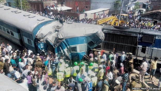Người dân, cảnh sát và nhân viên cứu hộ cố gắng giải cứu hành khách mắc kẹt trong đoàn tàu bi trật đường ray ở Uttar Pradesh, Ấn Độ. Tai nạn khiến ít nhất 34 người thiệt mạng.