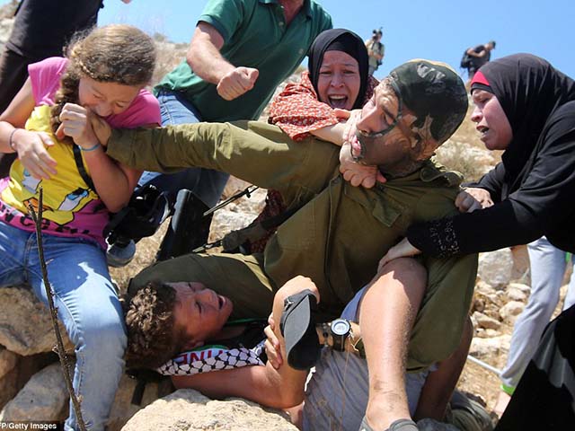 Bé gái Palestine không ngần ngại cào cấu, vật lộn thậm chí cắn vào tay binh sĩ Israel để giải cứu cậu bé trong cuộc biểu tình tại ngôi làng Nabi Saleh, Bờ Tây.
