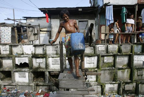 Người đàn ông lấy nước về nhà tại một nghĩa trang ở thành phố Manila.
