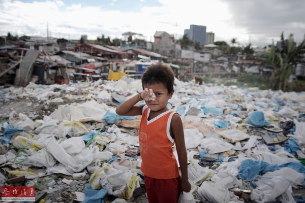 Em bé người Philippines đang đi nhặt rác.