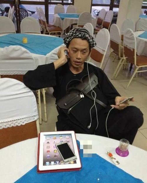 Hoài Linh vừa tranh thủ nghỉ ngơi trước show diễn, vừa dùng điện thoại và máy tính bảng để nhận show, kiểm tra công việc kinh doanh.