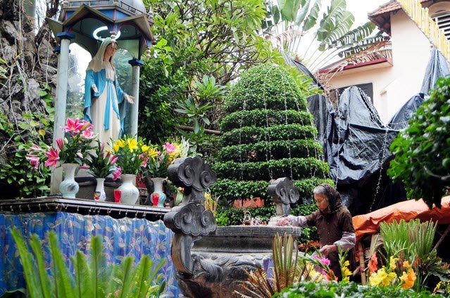 Nhà thờ Thái Hà cũng đã được trang hoàng lộng lẫy chuẩn bị cho đêm Giáng sinh. Trong ảnh: Bà Nguyễn Thị Đất (85 tuổi) đang dọn dẹp lư hương trước tượng Thánh Đức Mẹ.