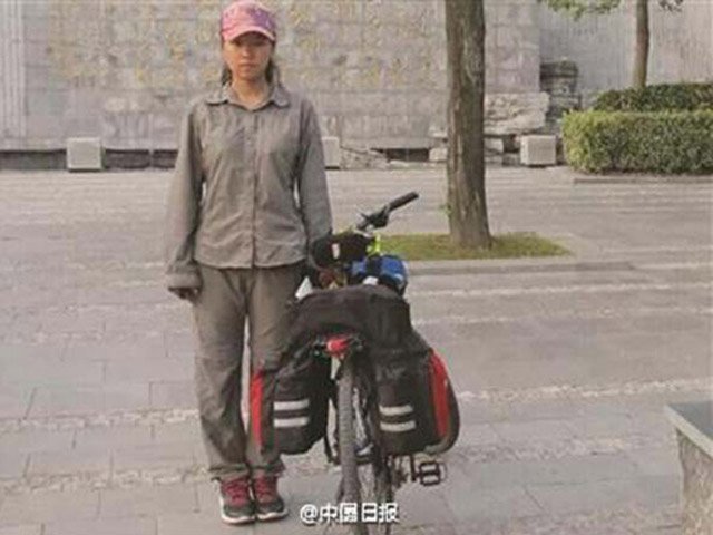 
Nữ sinh Yang Wanying đứng bên cạnh chiếc xe đạp đã cùng em vượt 2.500 km để tới trường đại học nhập học.
