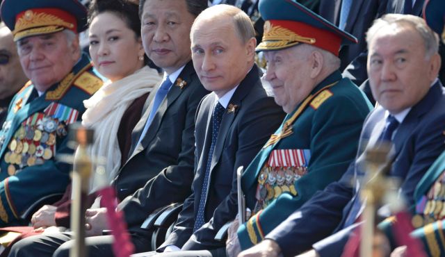 Ông Tập Cận Bình và phu nhân Bành Lệ Viện ngồi cạnh ông Putin xem lễ duyệt binh trên Quảng trường Đỏ ngày 9/5. Ảnh: Reuters.