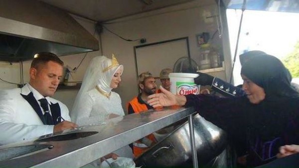 Cô dâu chú rể tự tay phân phát thức ăn cho những người tị nạn.