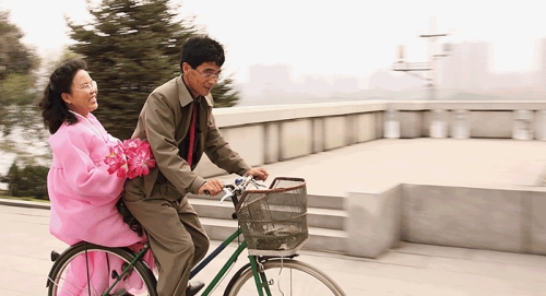 
Một cặp đôi đi dạo trên phố bằng xe đạp (Ảnh: Lachlan Towart)
