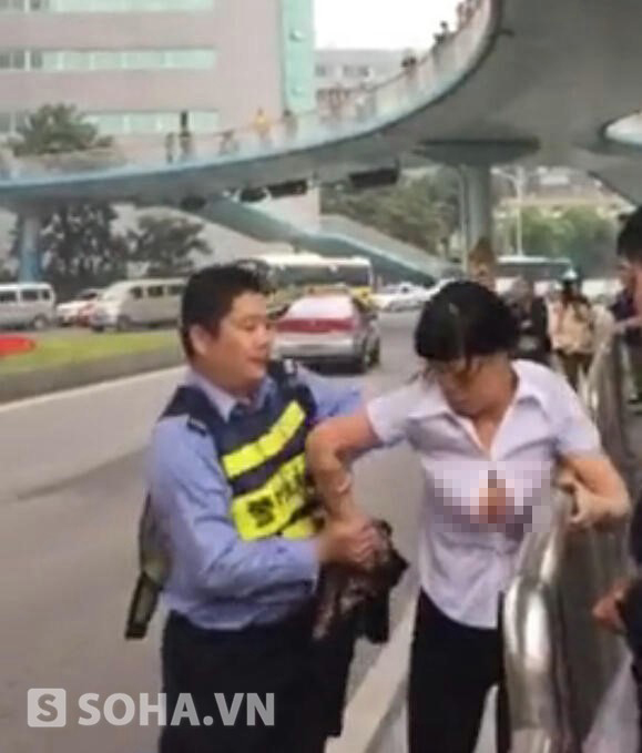 Người phụ nữ họ Cốc định leo rào để qua đường sau khi bị cảnh sát giao thông bắt xe đạp điện. Ảnh: QQ.