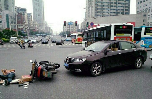 Người đi xe điện nằm ăn vạ trên đường sau khi va chạm với ô tô.