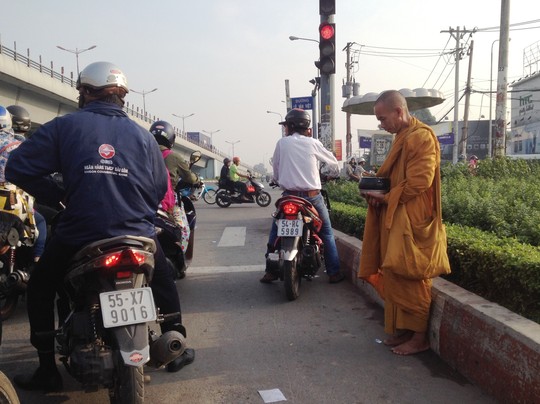  Tại ngã tư Thủ Đức (quận Thủ Đức) người đàn ông đội lốp thầy tu để khất thực, xin tiền vào ngày đầu năm mới 2015. 