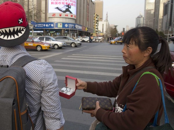 Một người phụ nữ đang bán đồng hồ giả tại Trung Quốc.