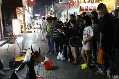 Nhiều người đứng xem Dongdong trên đường phố.