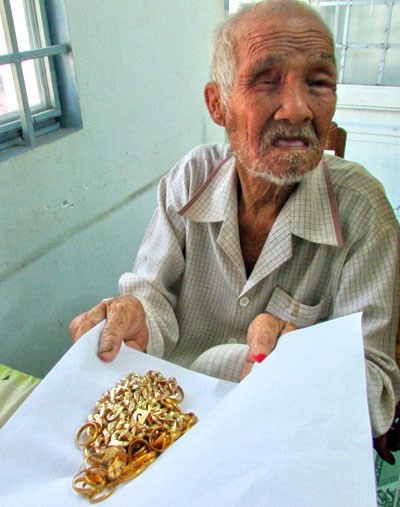 Ông lão ăn xin Nguyễn Văn Cưng cùng số vàng tích cóp được. 