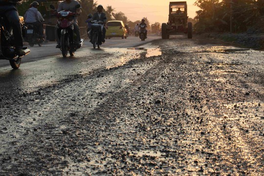 Mặt đường bong tróc, gồ ghề, đọng nước trên mặt đường trên Quốc lộ 91 đoạn qua phường Thới Long, quận Ô Môn.