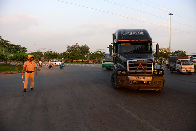 Cảnh sát giao thông điều tiết xe có trọng tải trên 5 tấn không được lưu thông vào quốc lộ 1 bắt đầu từ nút giao Bình Thuận (vòng xoay cầu vượt Nguyễn Văn Linh) - Ảnh: Hữu Khoa