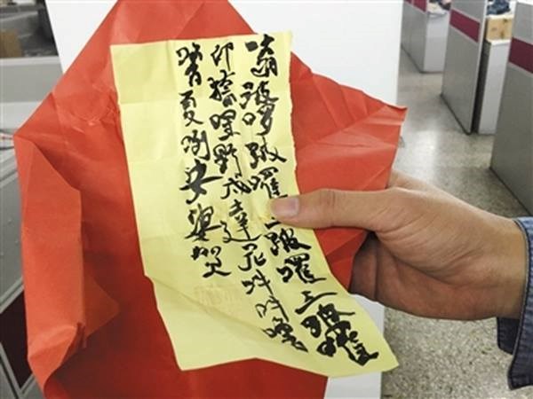 
Lang băm viết câu bùa chú lên giấy vàng cho bệnh nhân. (Nguồn: CCTVNews)
