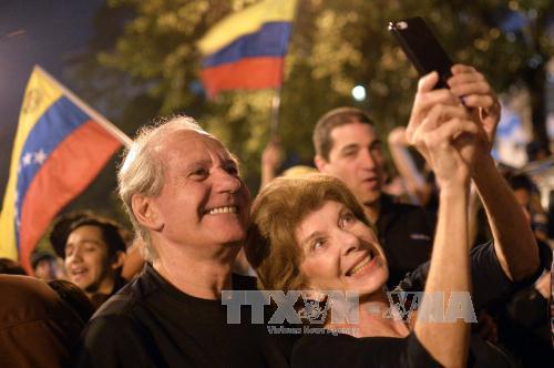 Những người ủng hộ Liên minh đối lập mừng chiến thắng tại thủ đô Caracas. Ảnh: AFP/TTXVN