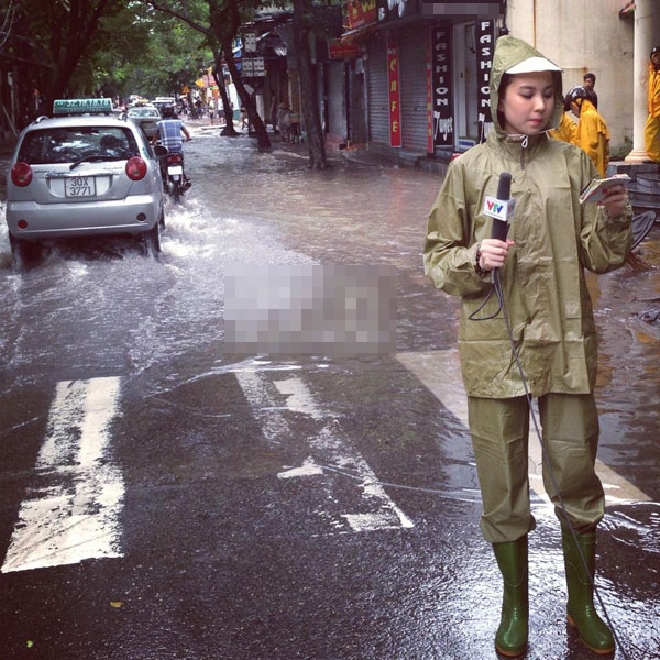 Không còn những bộ quần áo điệu đà đỏm dáng, BTV thời tiết Mai Ngọc mặc áo mưa đồng phục, đi ủng để tường thuật thông tin thời tiết tới mọi người.