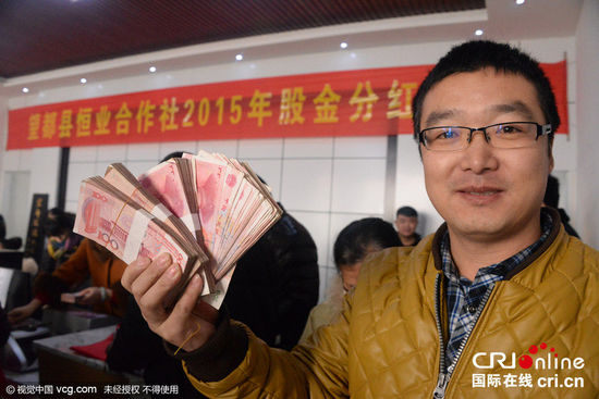 
Một hộ xã viên hào hứng khoe số tiền nhận được với các phóng viên của trang Cri.cn.
