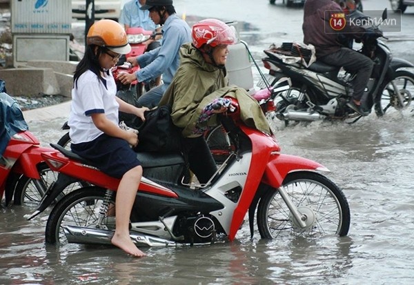 Một bức ảnh khác thể hiện tình mẫu tử khi người mẹ dắt xe đưa con đi qua đoạn đường ngập được người dùng mạng chia sẻ - (Ảnh: Quỳnh Trân)