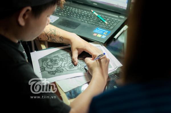 Phương và thợ xăm hình  Đinh Khang  đang thống nhất về họa tiết, vị trí xăm. Thợ xăm tiến hành scan họa tiết lên giấy để dán vào vị trí cần xăm trên người của Phương.