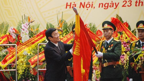 Chủ tịch nước Trương Tấn Sang gắn Huân chương Quân công hạng Nhất lên Quân kỳ quyết thắng của lực lượng Tình báo Quốc phòng. Ảnh: XB