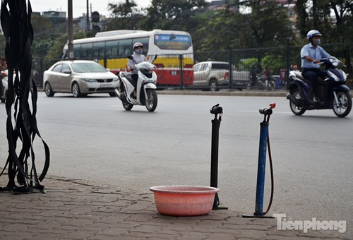 Hai chiếc bơm và một chậu nước là dấu hiệu của một cửa hàng bơm vá xe trên đường Giải Phóng (Hà Nội).