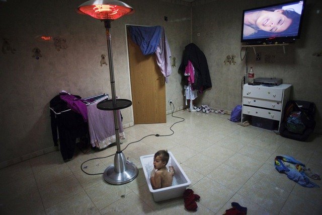 
Một cậu bé đang tắm nhưng cũng được xem TV ở ngoại vi Madrid (Tây Ban Nha) .
